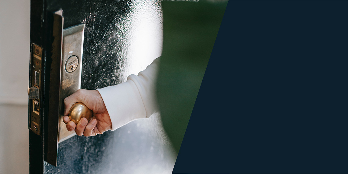 Hand på dörrhandtag.