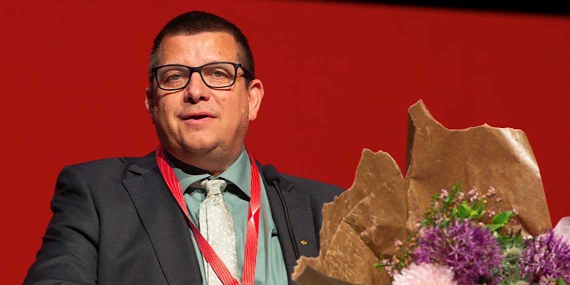 Veli-Pekka Säikkälä på podiet med en blombukett.