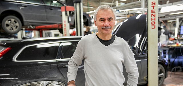 Porträtt av Dragan Mitrasinovic, förtroendevald IF Metall, på arbetsplatsen i motorbranschen med bilar och bildelar överallt.