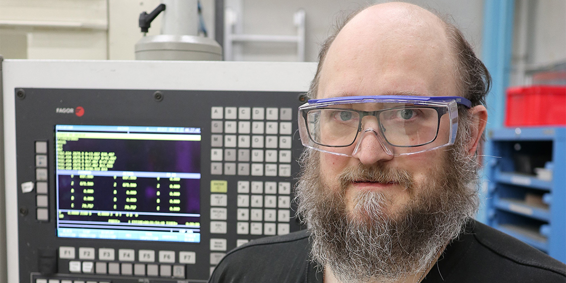 Porträtt av IF Metall-medlemmen Joachim Pettersson med skyddsglasögon på arbetsplatsen.