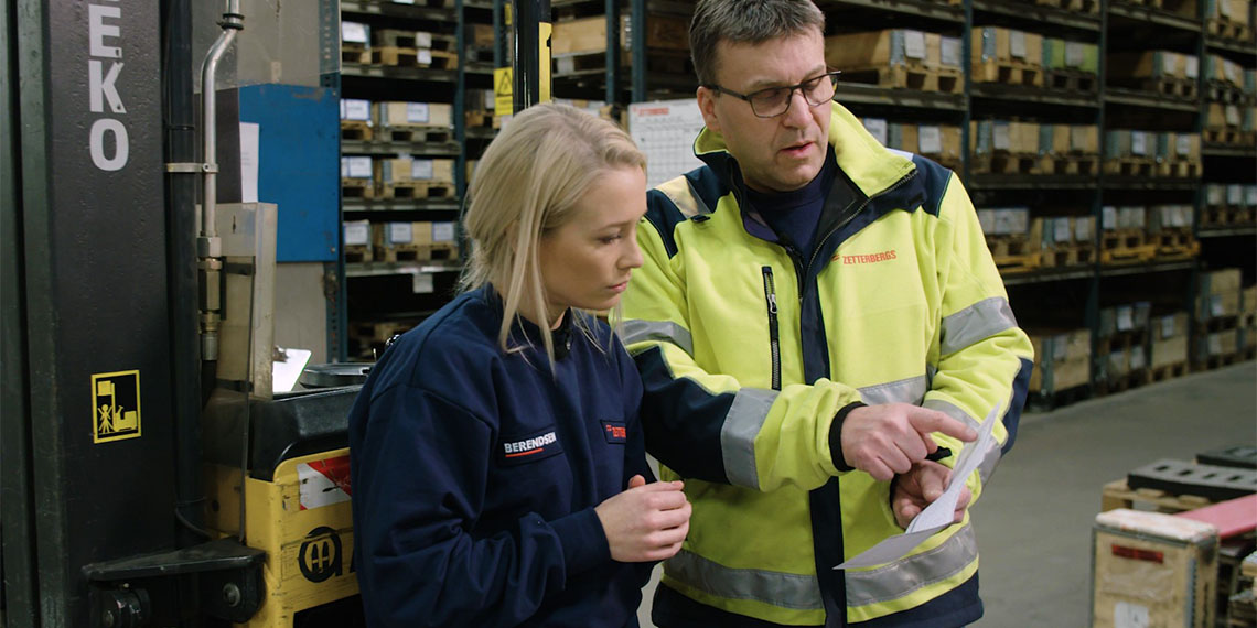 Skådespelaren Ellen Bergström introduceras till industrijobb av arbetsledare på industriarbetsplats.