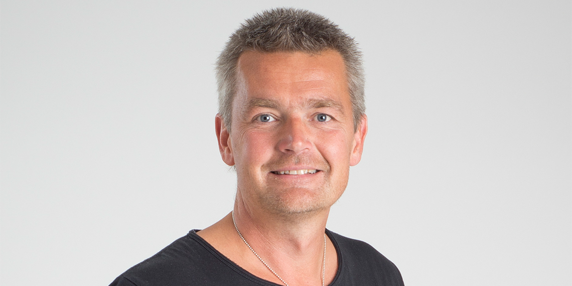 Porträtt av Peter Johansson, kassaföreståndare för IF Metalls a-kassa, mot ljus bakgrund.