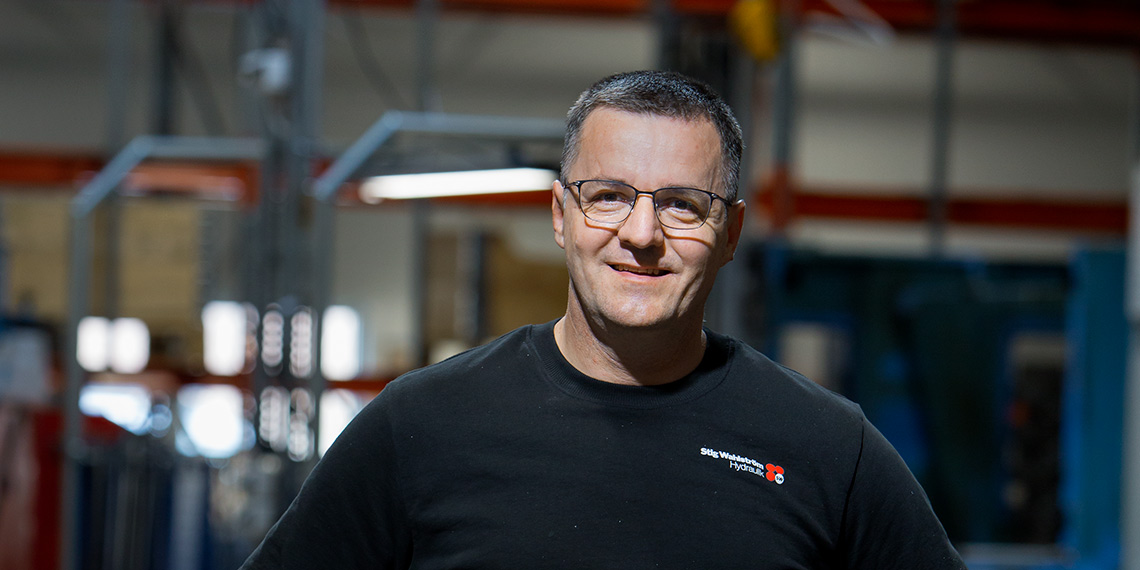 Svartklädd person med företagslogotyp på tröjan.