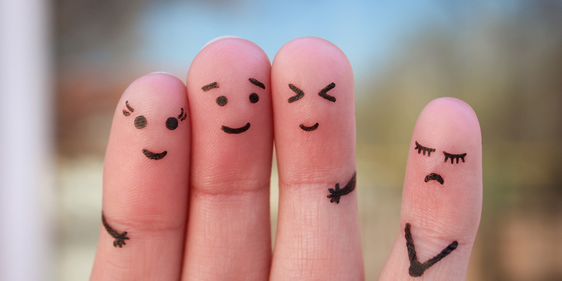 Fyra fingrar med ett ansikte målat på vardera, tre glada och ett ledset.