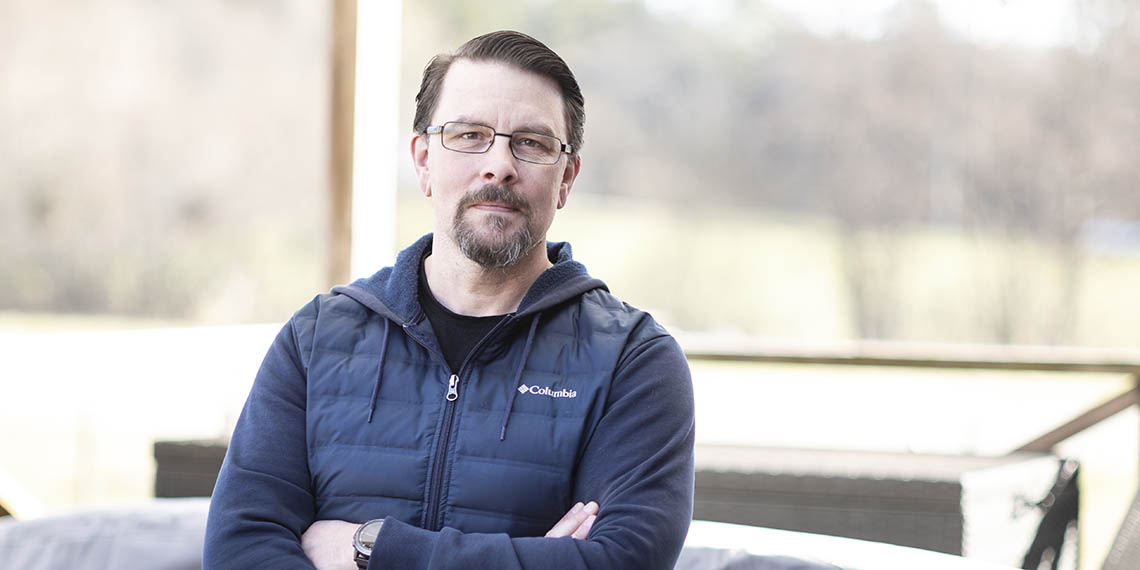Foto på Johan Järvklo. Han står utomhus och har en blå jacka på sig. 