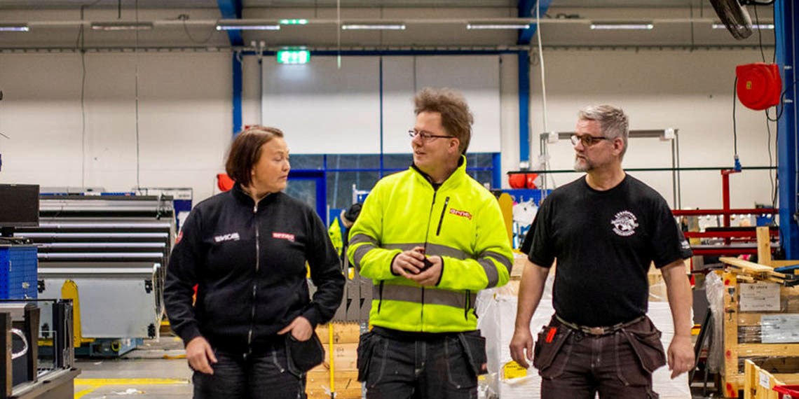 Foto på Martina Holmkvist Lundström,  Christoffer A Karlsson och Roland Magnil som går och samtalar i industrimiljö