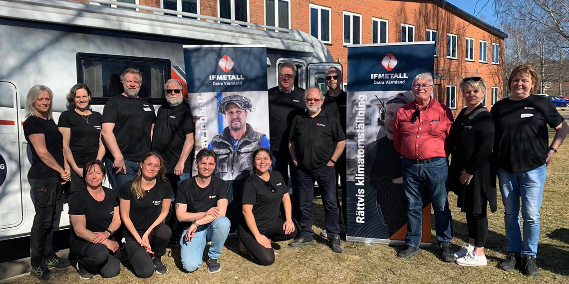 Flera personer står och sitter framför husbilen