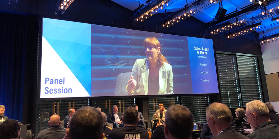 Foto från en kongresshall med Marie Nilsson på bild på en stor  projektduk