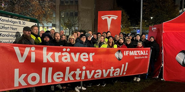 Folk som står utanför en Teslaverkstad. Framför sig har de en banderoll där det står Vi kräver kollektivavtal!