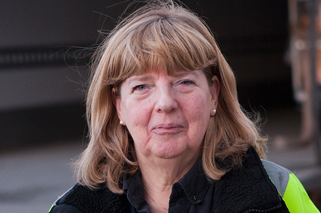 Person i arbetskläder utomhus.