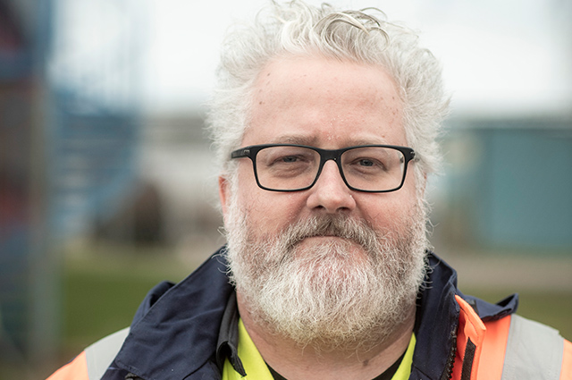 Person utomhus mot suddig bakgrund.